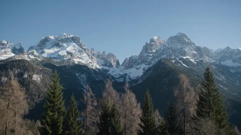 Snowy rocky mountain range green forest handheld shot Stock Footage 341340688