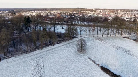 Snowy rural landscape with open fields scattered leafless trees and distant 動画素材 328259273