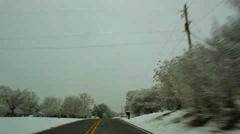 Snowy rural road and snow blowing from trees Stock Footage