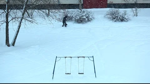 Snowy scene with swing. Anonymous and dog walking from left to right. Vídeos de archivo 951553