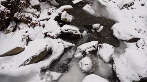 Snowy Stream Surrounded by Rocks Stock Footage 296646308