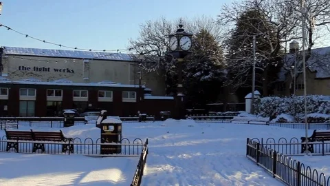 Snowy town center with clock tower, panning to pub/restaurant Video stock 83358723