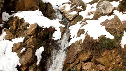 Snowy waterfall down the mountain in slow motion. snow Dissolves into waterfall Stock Footage 130460282