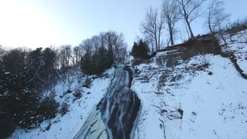 Snowy Waterfall Over Frozen River – Aerial Winter Nature Scene Stock Footage 322867775