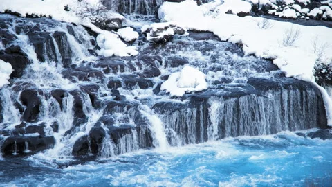 Snowy waterfall at winter. Mountain river with pure glacier water in 8k. Iceland Stock Footage 234072458