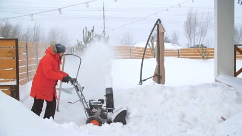 Snowy winter concept. Young man removes snow with a snowplower Stock Footage 178952007
