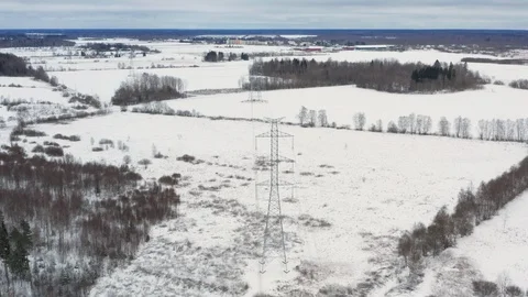 Snowy winter fields with a ultra high voltage power line tower underneath Stock Footage 101138683