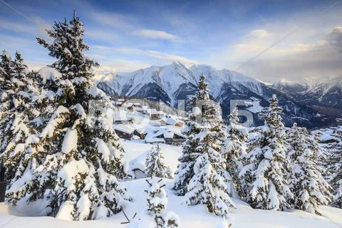 Snowy woods and mountain huts framed by the winter sunset, Bettmeralp, district Stock Photos