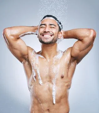 So clean and fresh. Studio shot of a handsome young man taking a shower against Stock Photos