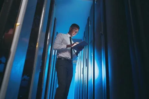So far, so good. a young IT specialist standing alone in the server room and 스톡 사진