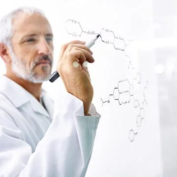So many molecules... this could get messy. a mature male scientist drawing the Stock Photos
