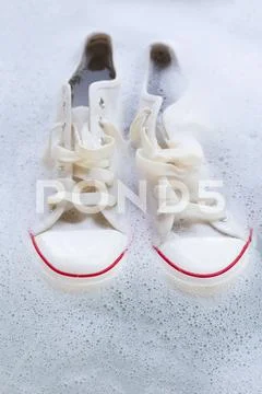 Soak shoes before washing. Dirty sneakers. Stock Photos