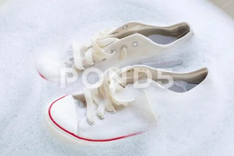 Soak shoes before washing. Dirty sneakers. Stock Photos