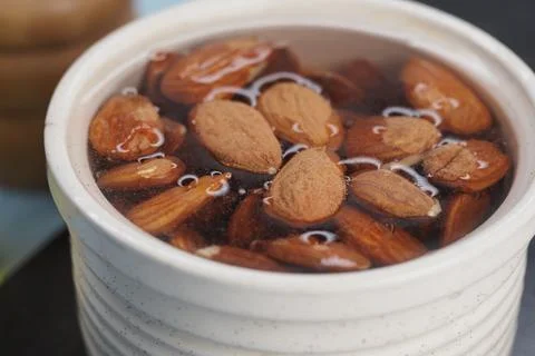Soaking almonds in water for cooking process Stock Photos