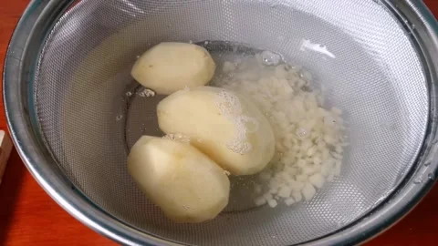 Soaking Fine Diced Raw Potatoes in a Bowl of Water Stock Footage 241511462