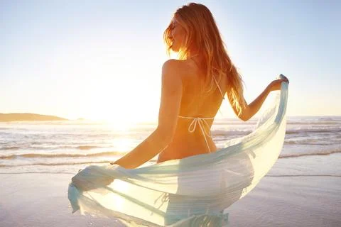 Soaking up the last rays of daylight. an attractive young woman in a bikini Stock Photos