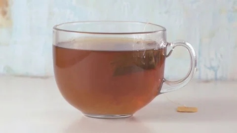 Soaking a tea pack in glass cup with slow motion. Stock Footage 70589844