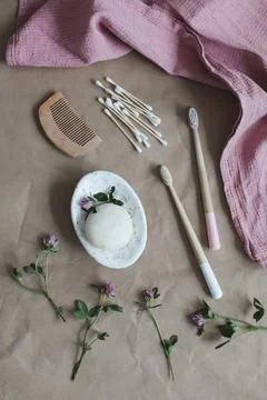 Soap bar or solid shampoo on a soap dish, bamboo toothbrush and towel top view Stock Photos