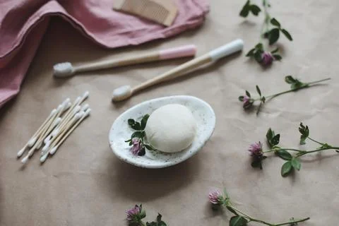 Soap bar or solid shampoo on a soap dish, bamboo toothbrush and towel top view Foto stock