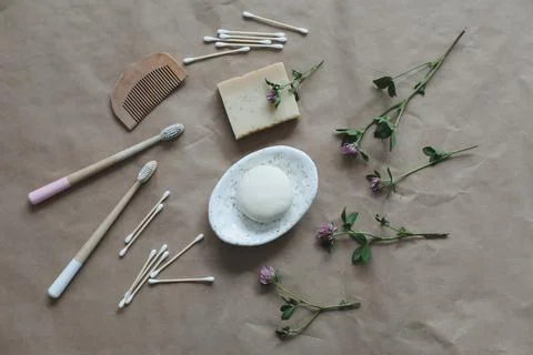 Soap bar or solid shampoo on a soap dish, bamboo toothbrush and towel top view Stock Photos