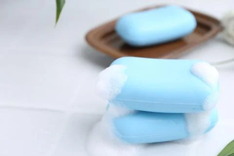 Soap bars with foam on white table, closeup. Space for text 写真素材