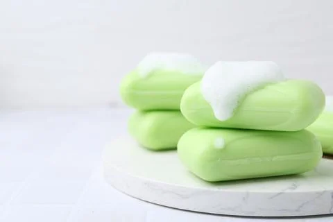 Soap bars with foam on white table, closeup. Space for text 写真素材