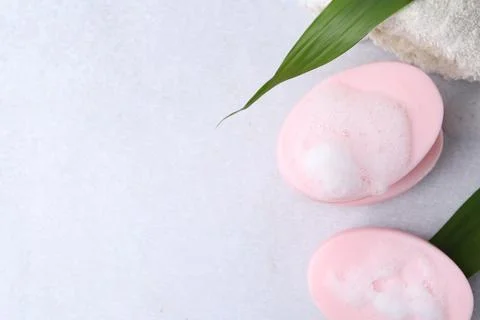 Soap bars with foam on white table, flat lay. Space for text 스톡 사진