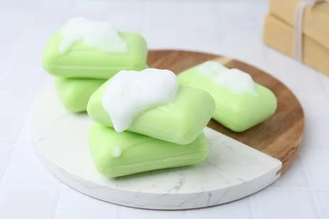 Soap bars with foam on white table, closeup Stockfoto's