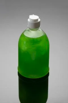 Soap bottle on grey background with shadow. Green color dishwashing liquid Stock Photos