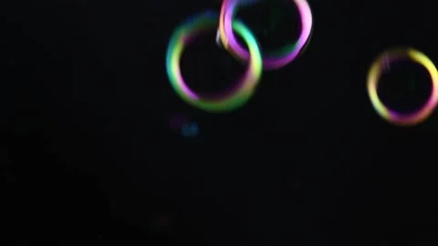 Soap bubble background. Colorful soap bubbles fly across black background. Stock Footage 220660528
