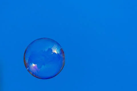 Soap bubble floating through a blue sky Stock Photos