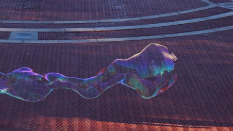 Soap Bubble Shape Floating above Ground Expanding and Bursting, Dragged by Stock Footage 220539140