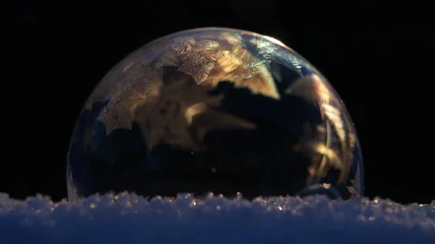 Soap bubble on snow freezing in cold winter weather on black background Stock Footage 262295811