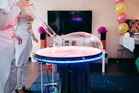 Soap bubble table with a big soap ball. Animators inflating a soap ball. Show Stock Photos