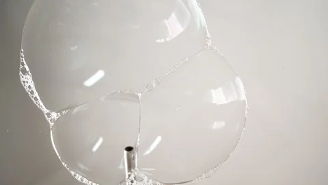 Soap bubbles are blowing on the glass. On a white background. 4K Stock Footage 268009017