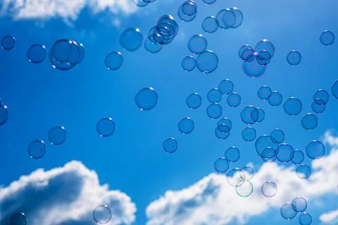 Soap bubbles on blue cloudy sky background Stock Photos