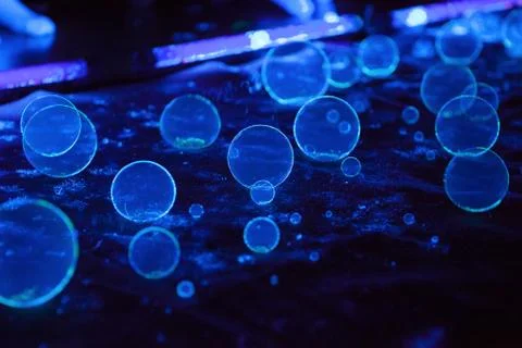 Soap bubbles on dark background in fluorescent light Stock Photos