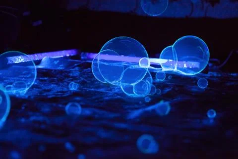 Soap bubbles on dark background in fluorescent light Stock Photos