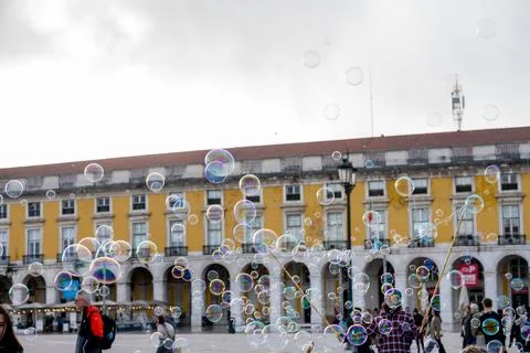 Soap bubbles floating above crowd in Lisbon square Foto stock