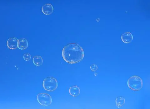 Soap bubbles floating in a blue sky Stock Photos