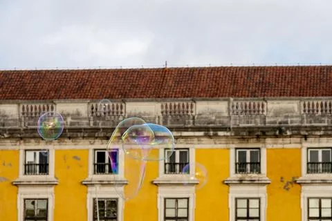 Soap bubbles floating in front of historic Lisbon facade Stock Photos