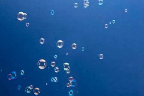 Soap Bubbles Floating Over Blue Background Foto stock