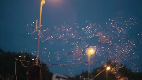 Soap Bubbles Floating Under Street Lights at Night Stock Footage 340424256