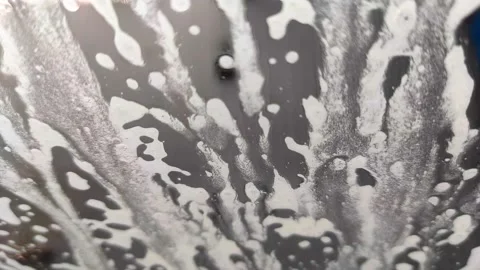 Soap bubbles flowing over car washed with foam Stock Footage 168294365