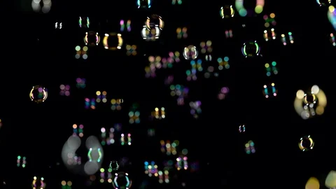 Soap bubbles fly in the air and shimmer in different colors. Black background Stock Footage 96224275