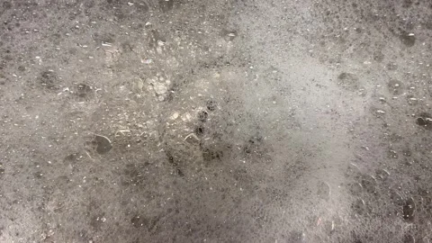 Soap bubbles foam burst and go down the drain Stock Footage 243849779