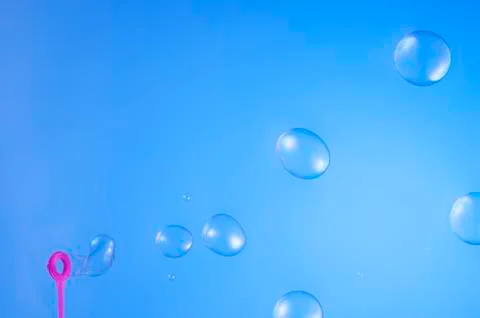 Soap bubbles isolated on blue background Stock Photos