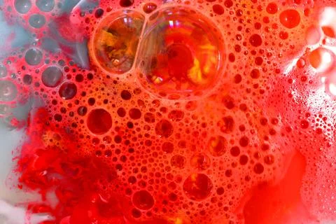 Soap bubbles on red liquid background. Stock Photos