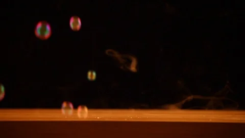 Soap bubbles smoke wooden table dark background hd footage Stock Footage 99861914