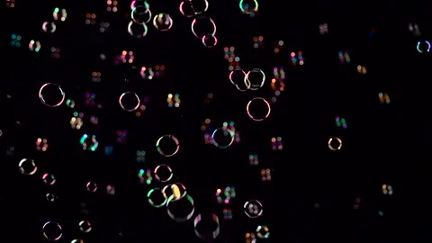 Soap bubbles start flying from the center and burst. Slow motion. Black Stock Footage 98004495